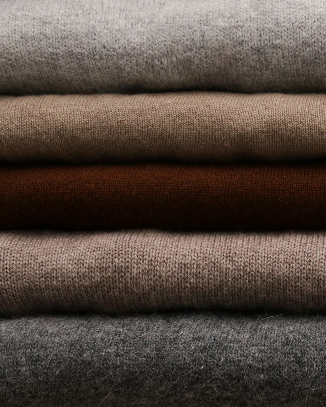 Folded wool and cashmere cloth in camel, brown and grey